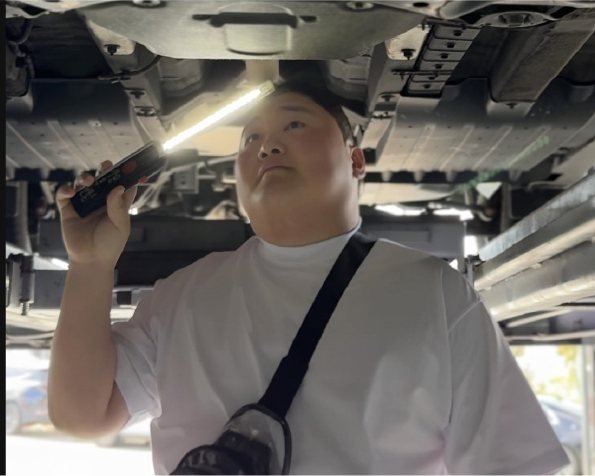 직영 카센터 리프트 아래에서 차량 하부를 점검하는 모습