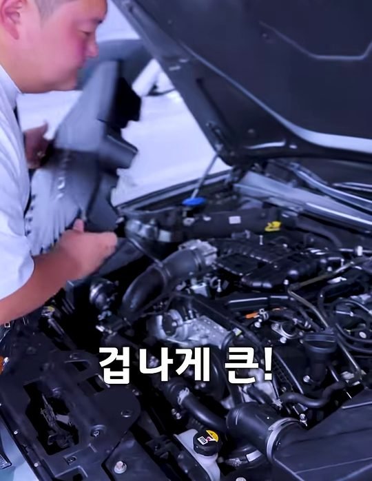 중카TV 영상에서 G70 보닛을 열고 엔진룸을 보는 장면