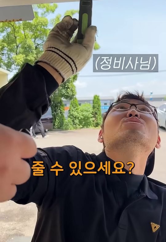 중카TV 영상에서 정비사가 하부를 확인하는 장면